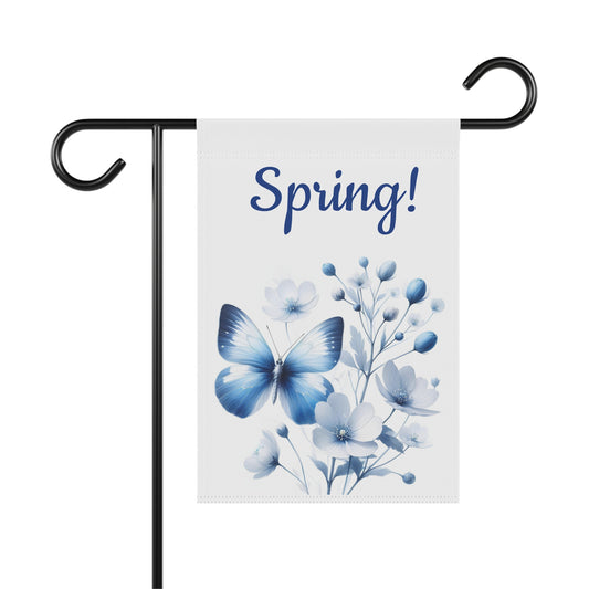 White garden flag with "Spring!" in blue text, featuring a large blue butterfly and clusters of delicate blue and white flowers.