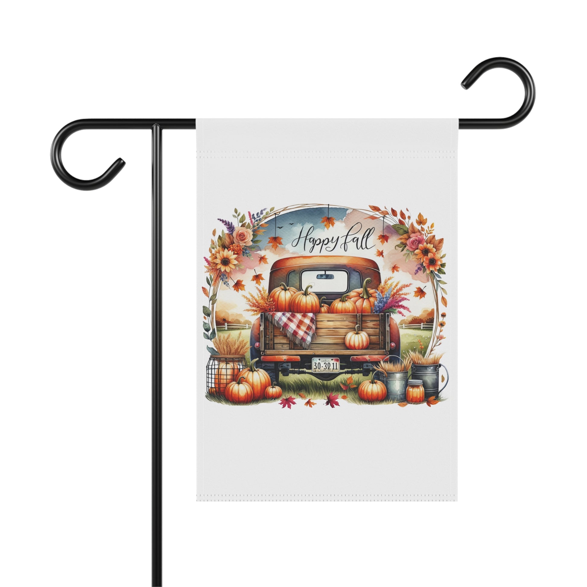 White garden flag with a vintage orange pickup truck full of pumpkins and fall flowers, surrounded by an autumn floral wreath, with "Happy Fall" script above. Additional pumpkins and fall decor are at the base of the truck.