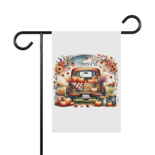 White garden flag with a vintage orange pickup truck full of pumpkins and fall flowers, surrounded by an autumn floral wreath, with "Happy Fall" script above. Additional pumpkins and fall decor are at the base of the truck.
