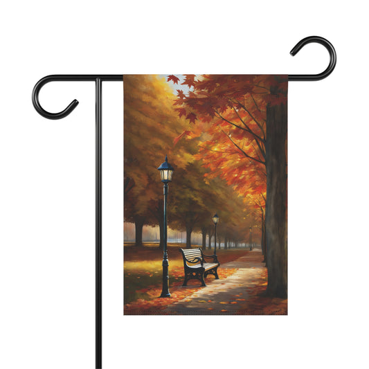 Garden flag showing a vibrant autumn park lane with bright orange and red fall trees, a streetlight, and a park bench.