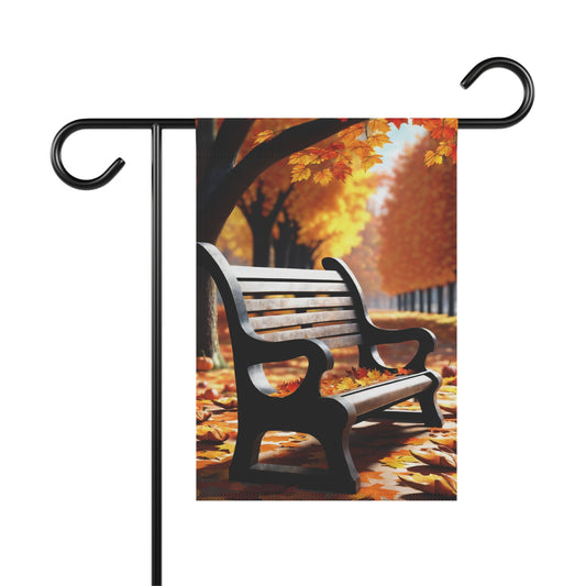 Autumn garden flag with a dark park bench covered in orange and yellow fallen leaves, and fall trees in the background