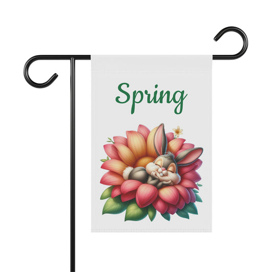 Sleeping bunny snuggled in a pink and orange flower on a white garden flag with "Spring" in green text.