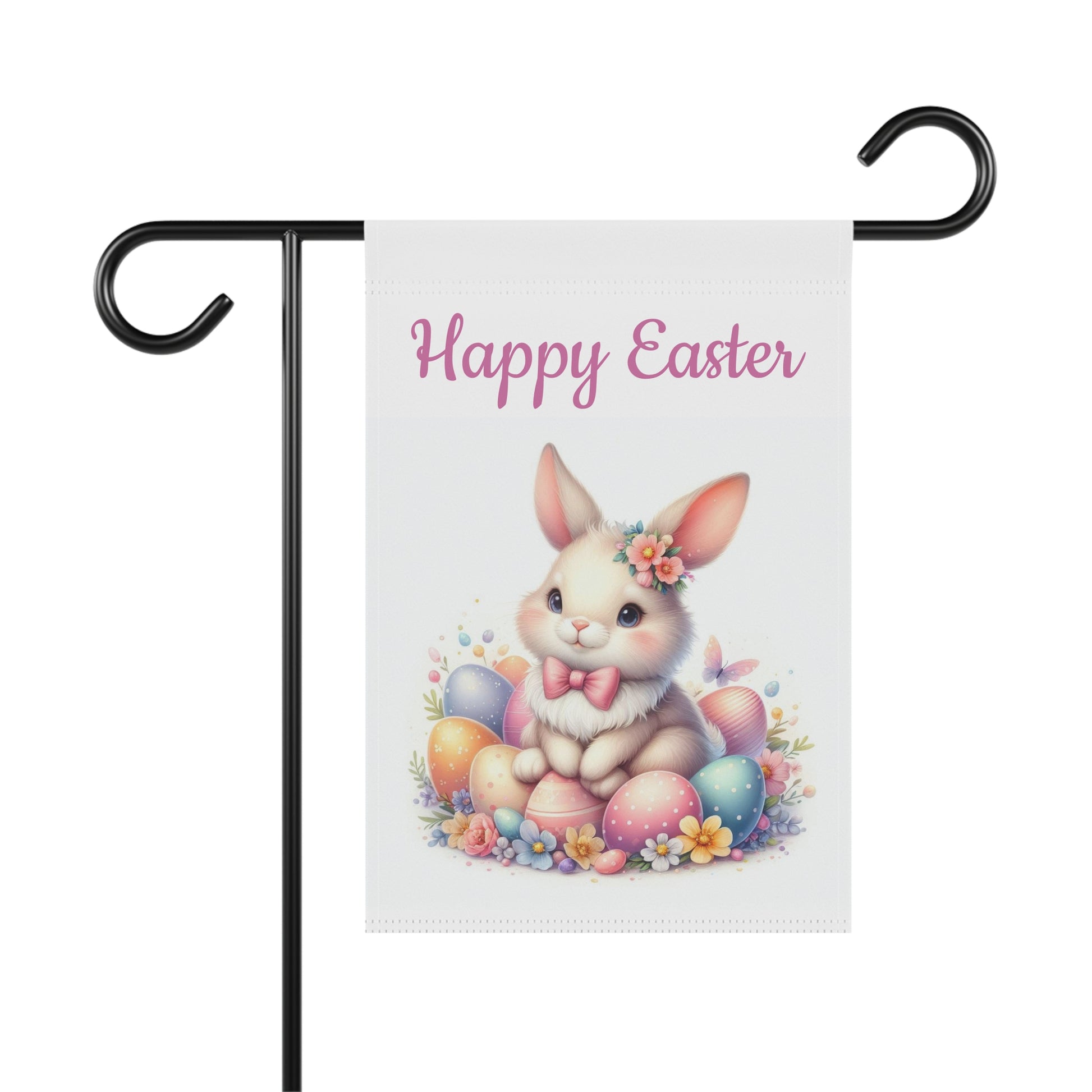 "Vertical white garden flag displaying 'Happy Easter' in purple script above a detailed illustration of a cute white rabbit among pastel painted Easter eggs, pink and yellow wildflowers, and green foliage, with butterflies, shown on a black metal garden flag holder."