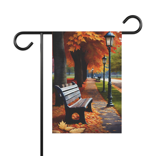 Garden flag showing a vibrant autumn park pathway with orange and red fall trees, multiple streetlamps, and a park bench with fallen leaves.