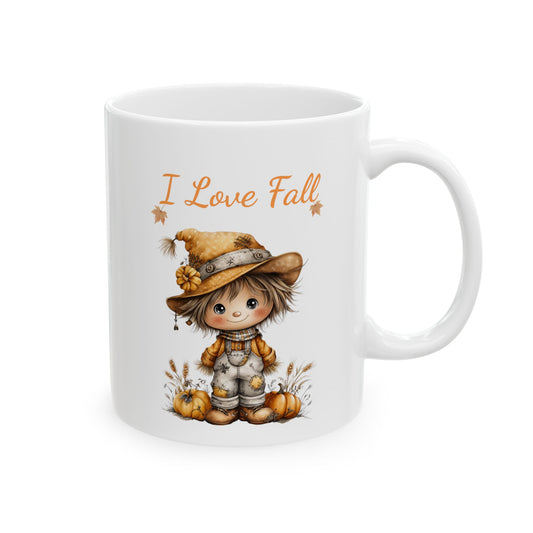 I Love Fall ceramic coffee mug featuring a cute illustration of a small whimsical scarecrow wearing a floppy hat and overalls, standing between pumpkins and wheat stalks under orange text.