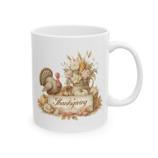White ceramic coffee mug printed with brown Thanksgiving script on a rustic parchment scroll below a turkey, pumpkins, and a pitcher of fall flowers