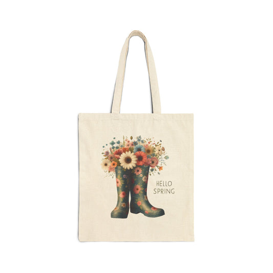 Canvas tote bag with a "Hello Spring" print featuring a pair of floral rain boots filled with a bouquet of wildflowers.