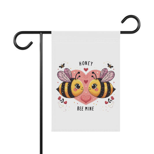 Cute Valentine's Day garden flag with two cartoon bees facing each other on a pink heart, and the text "Honey" and "Bee Mine," hanging on a black metal flag holder.

