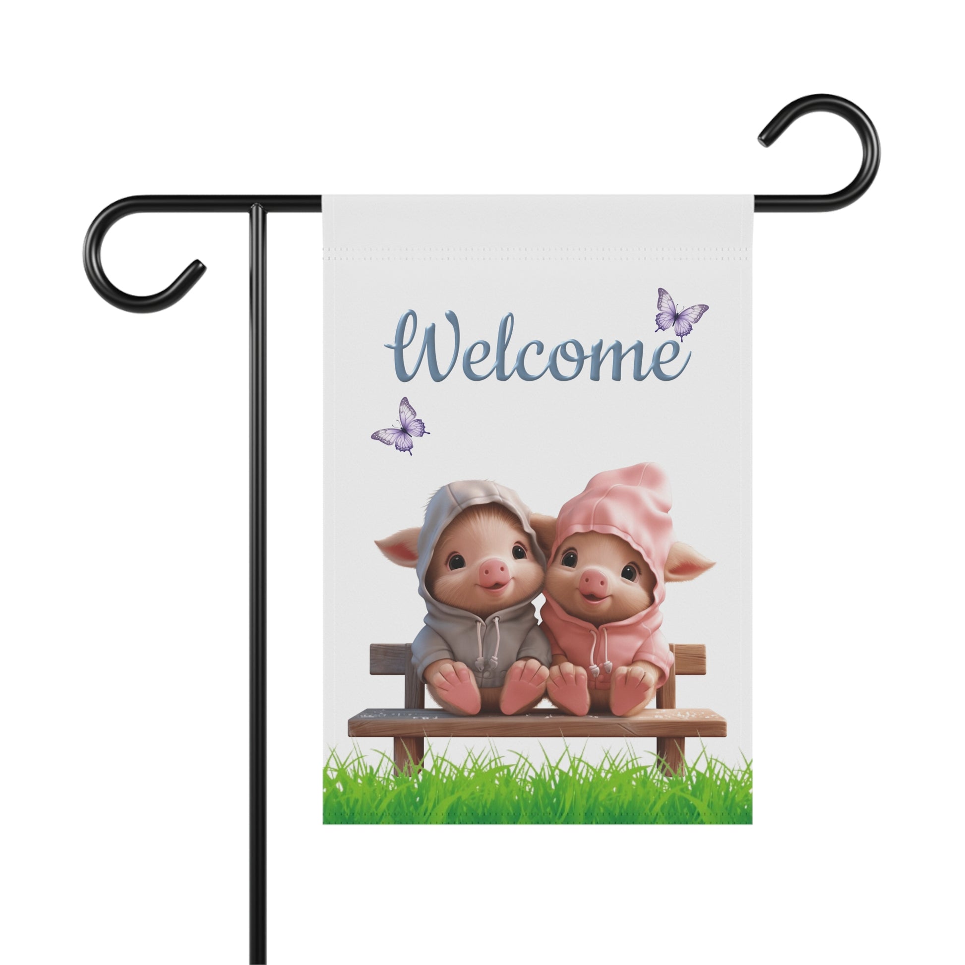 Two cute piglets in hoodies sitting on a wooden bench on green grass under blue Welcome text with purple butterflies garden flag