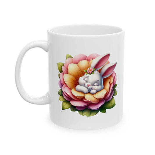 White ceramic mug with a cute white baby bunny sleeping peacefully inside a large pink and orange blooming flower, wearing a tiny flower crown.

