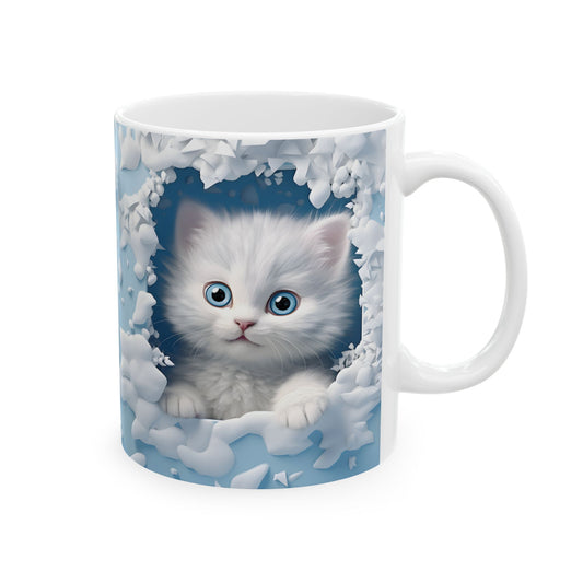 White ceramic coffee mug with a 3D-style illustration of an adorable fluffy white kitten with bright blue eyes, peeking from a white snowy or icy frame on a light blue background.