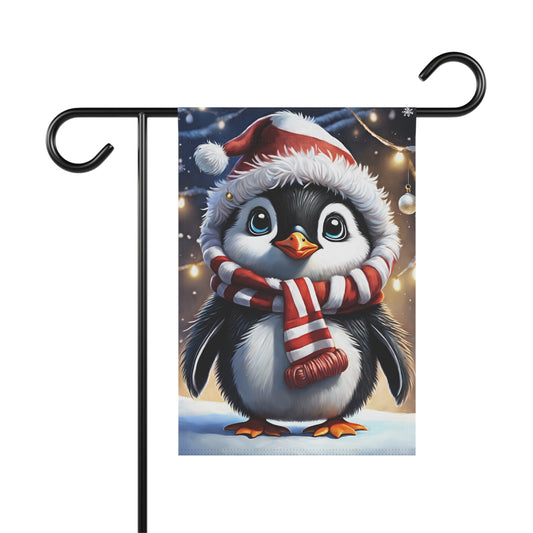 Adorable baby Christmas penguin garden flag wearing a Santa hat and a red and white striped scarf, in a snowy scene with blurred holiday lights, on a black metal garden flag stand

