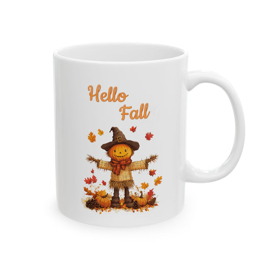 White ceramic coffee mug with a cute cartoon scarecrow with a pumpkin head, surrounded by pumpkins and fall leaves, and the text "Hello Fall."
