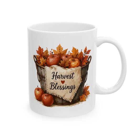 White ceramic mug featuring autumn harvest illustration beneath script text reading Harvest Blessings.