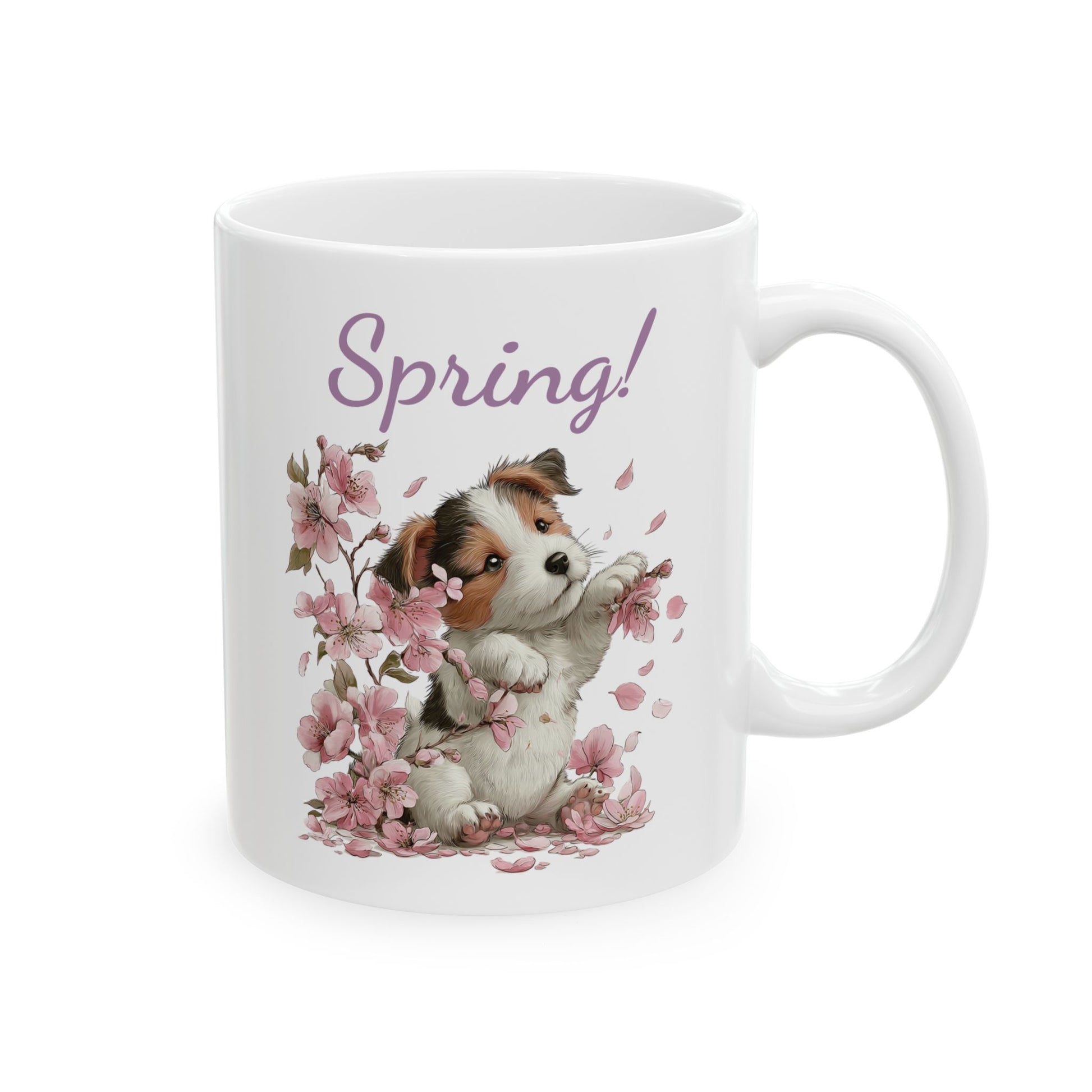 White ceramic mug printed with purple Spring! text and a small tricolor puppy playing with pink cherry blossoms
