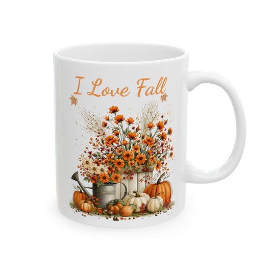 White ceramic mug featuring autumn floral harvest illustration beneath orange script text reading I Love Fall.