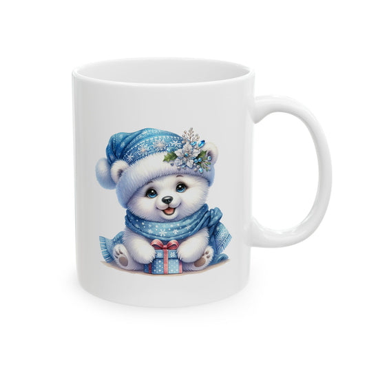 White ceramic coffee mug printed with an illustration of a cute white polar bear cub wearing a blue winter hat and scarf holding a blue gift box