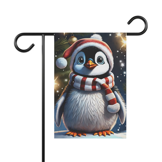 Adorable baby penguin garden flag wearing a Santa hat and a red and white striped scarf, standing in snow with blurred Christmas lights in the background, on a black metal garden flag stand.

