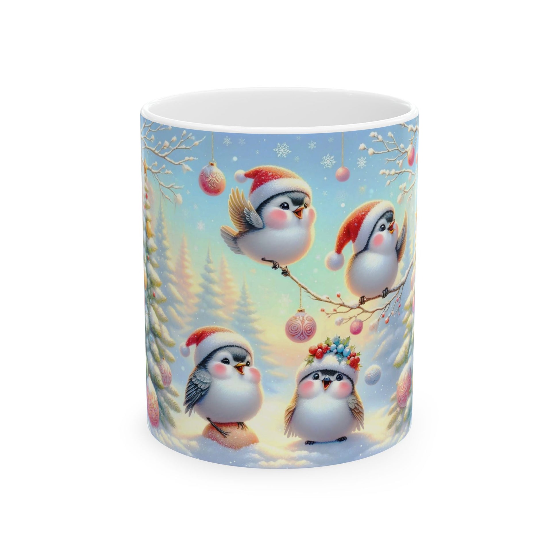 White ceramic coffee mug with a charming illustration of four cute, fluffy birds in Santa hats and one with a festive headpiece, sitting on a branch and in the snow, surrounded by a snowy winter landscape with pink and blue sky.

