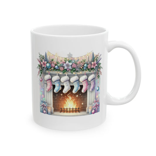 White ceramic coffee mug printed with an illustration of a cozy brick fireplace with glowing fire, hung pastel stockings, and floral garland decor