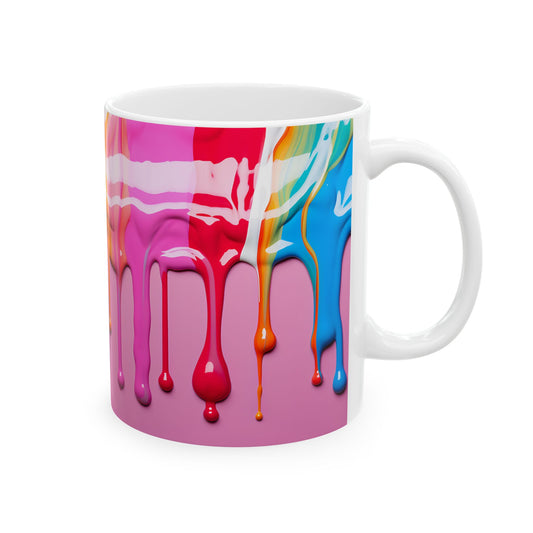 White ceramic coffee mug with a vibrant abstract design of colorful paint drips in blue, orange, red, and pink, flowing down from the top against a solid pink background.