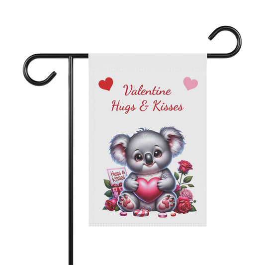 Valentine’s Day garden flag with cute koala holding a heart, surrounded by roses, candies, and a Hugs & Kisses gift box on a white background