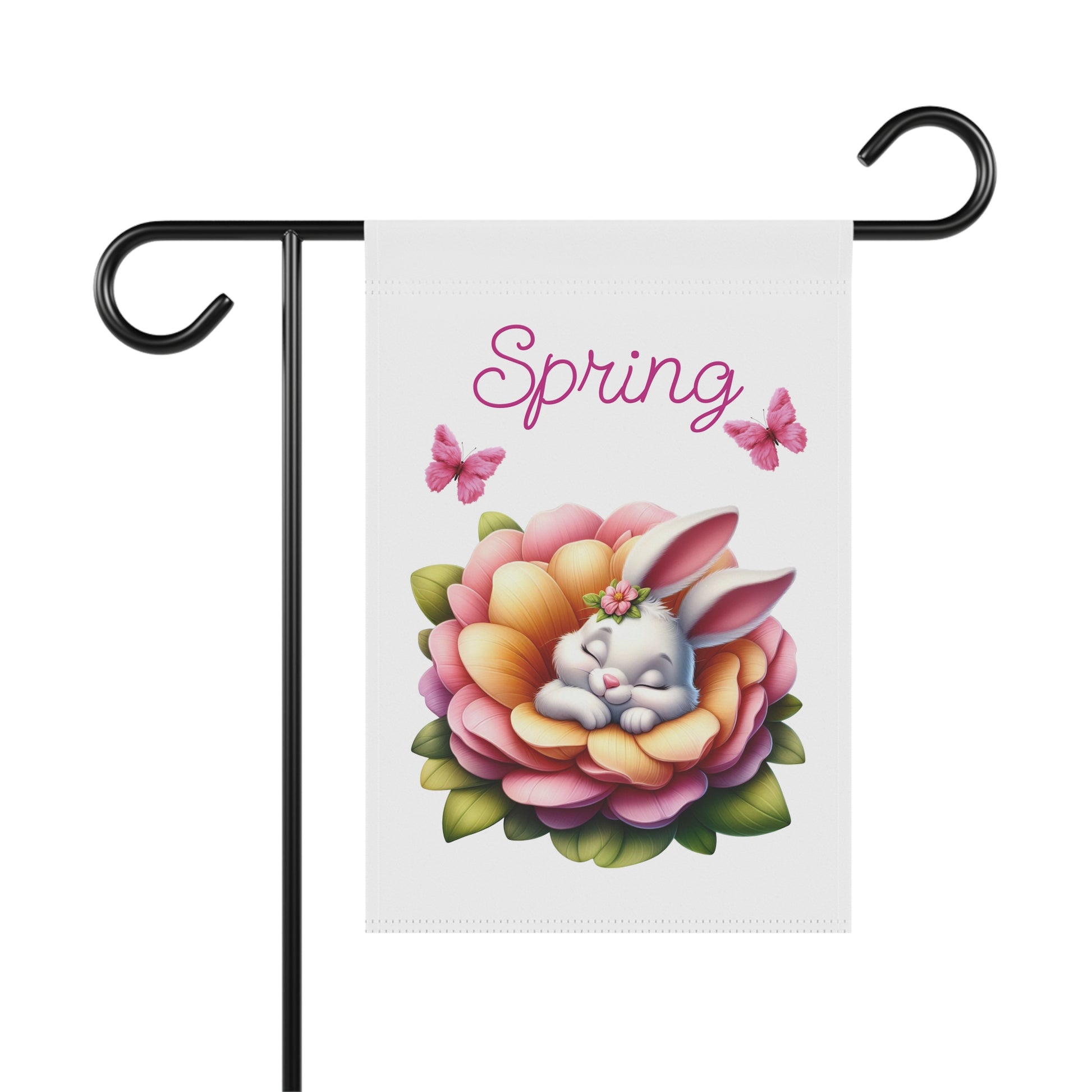 White garden flag displayed on a black metal pole, featuring a cute white bunny sleeping peacefully inside a large pink and orange flower with green leaves, two pink butterflies, and the word "Spring" in purple script above.

