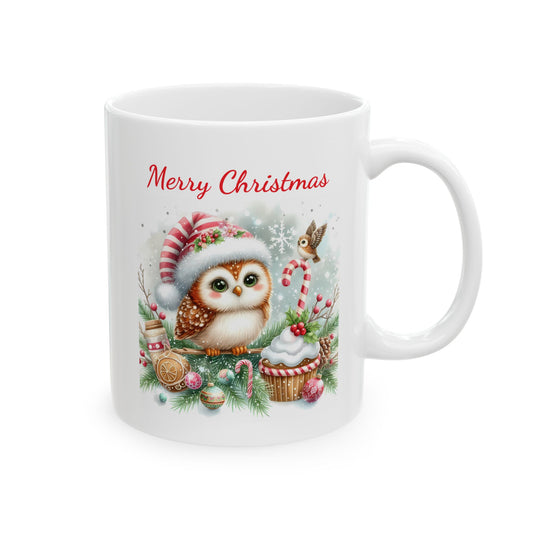 White ceramic coffee mug with a cute illustration of a fluffy owl wearing a striped Santa hat, sitting on a branch with Christmas decorations, candy canes, and a cupcake, with the words "Merry Christmas" in red script text above it.

