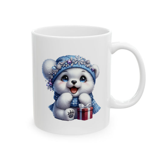 White ceramic coffee mug printed with an illustration of a fluffy white polar bear cub in a blue snowflake beanie sitting next to a red gift box