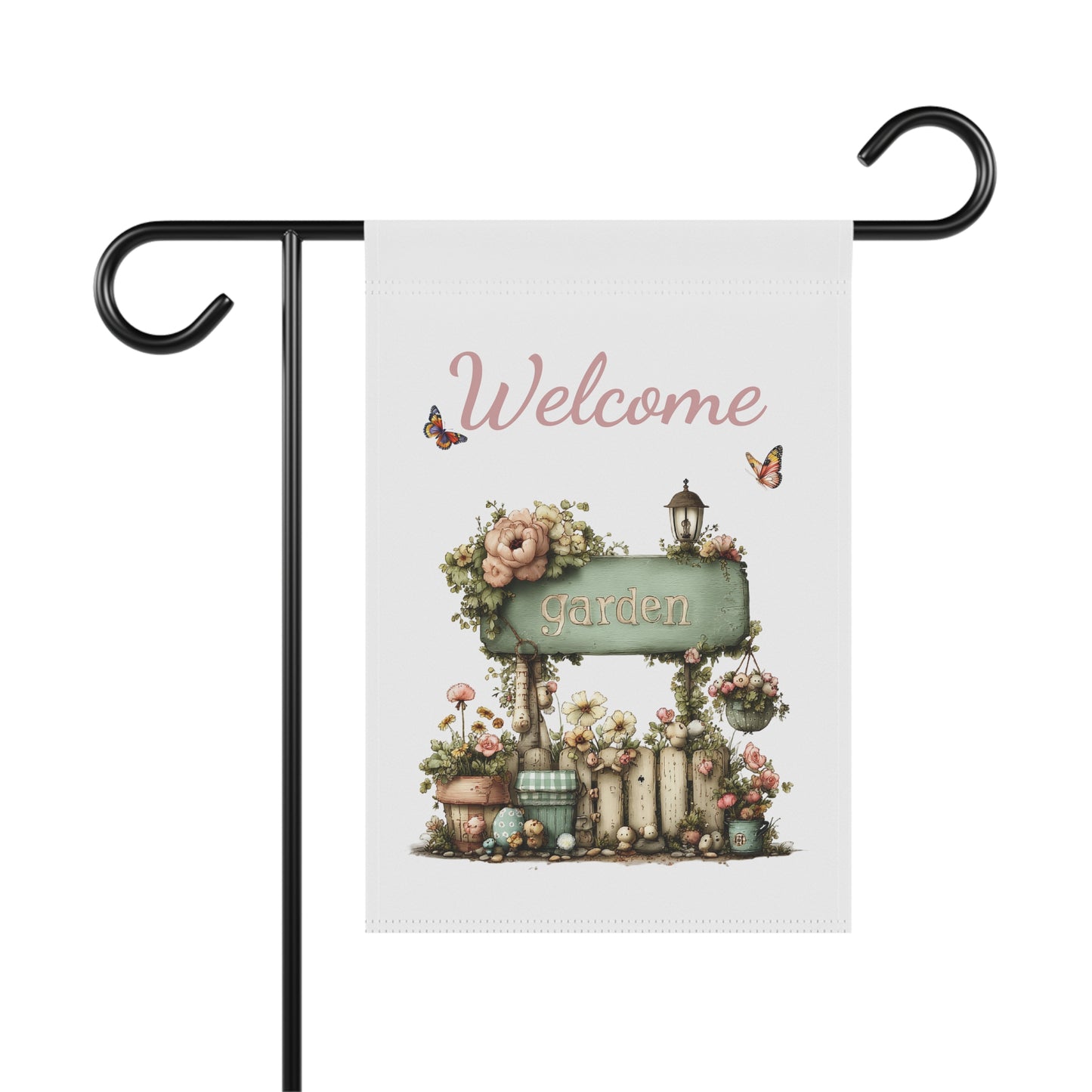 Garden flag on a black metal stand printed with soft pink script Welcome text above a rustic green garden sign on a flower-draped fence with butterflies