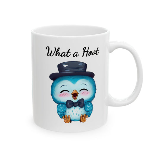 White ceramic coffee mug with a cartoon illustration of a cute, plump blue owl with big eyes, wearing a black top hat and bow tie, with black text above reads "What a Hoot".