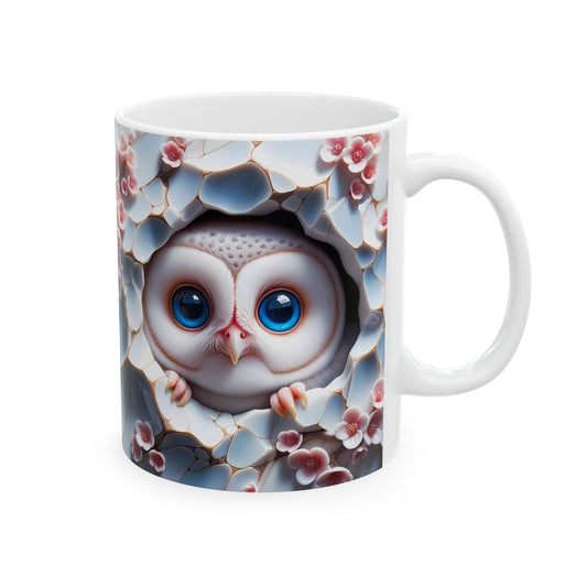 White ceramic coffee mug with a 3D-style illustration of an adorable baby owl with large blue eyes, peeking out from a cracked, textured white and blue background, surrounded by pink flowers.