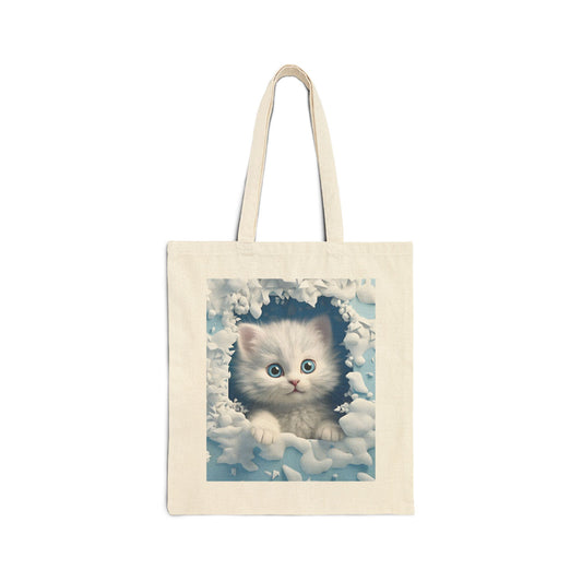 Fluffy white kitten with blue eyes framed in a snowy design on a canvas tote bag.