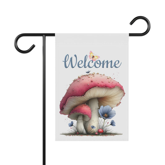 Outdoor garden flag featuring a whimsical red mushroom illustration with a butterfly beneath blue script text reading Welcome.
