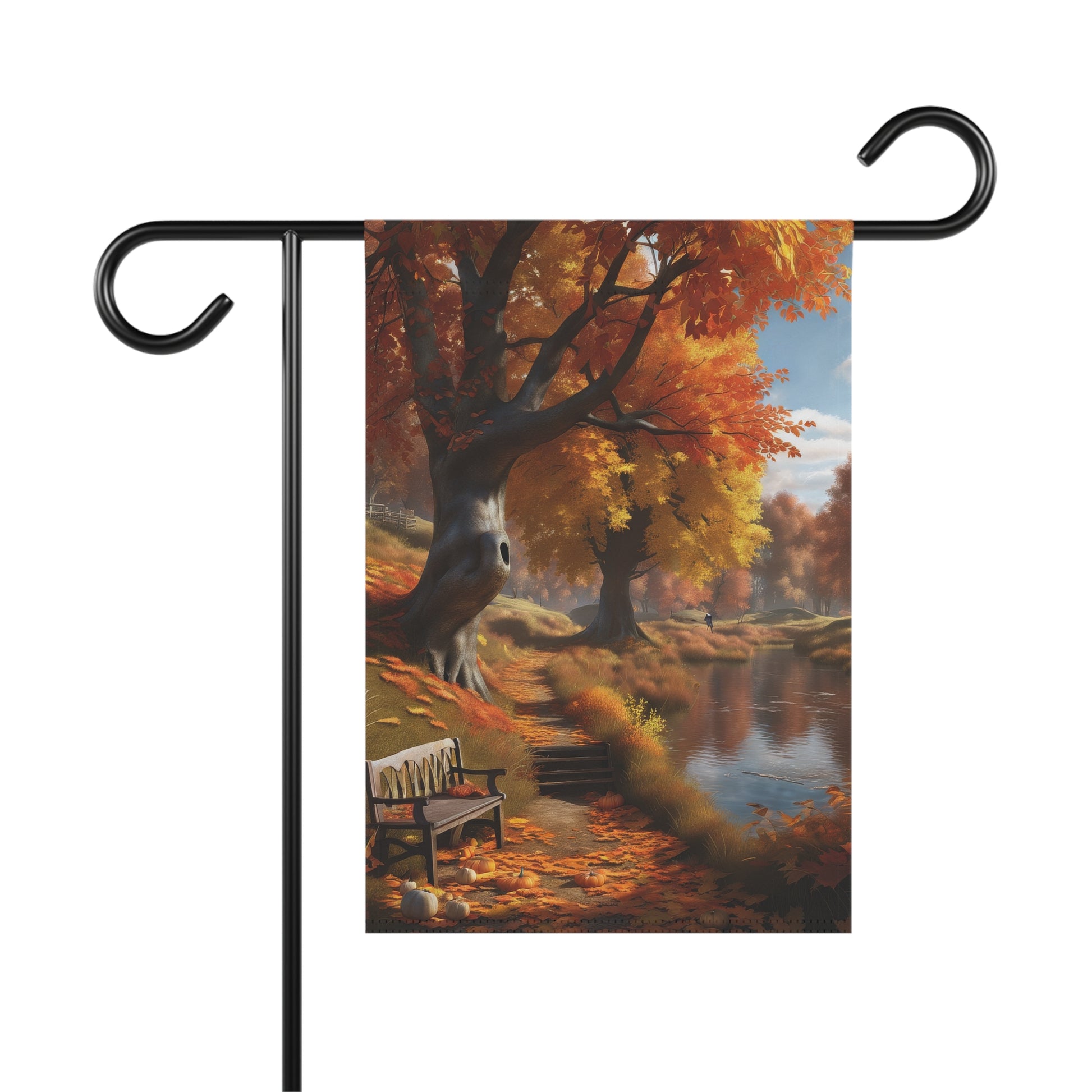 Garden flag depicting a scenic autumn landscape with a calm lake reflecting trees with vibrant orange and yellow fall foliage, a wooden park bench on the shore, and fallen leaves with small pumpkins on the ground. 