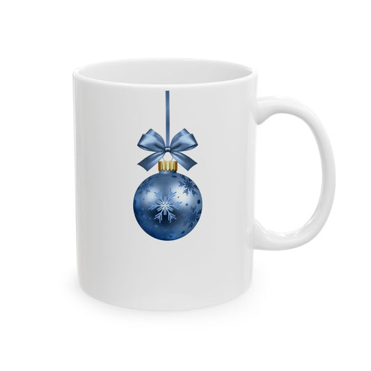 White ceramic coffee mug printed with a hanging blue Christmas ornament featuring snowflake patterns, a gold cap, and a blue bow