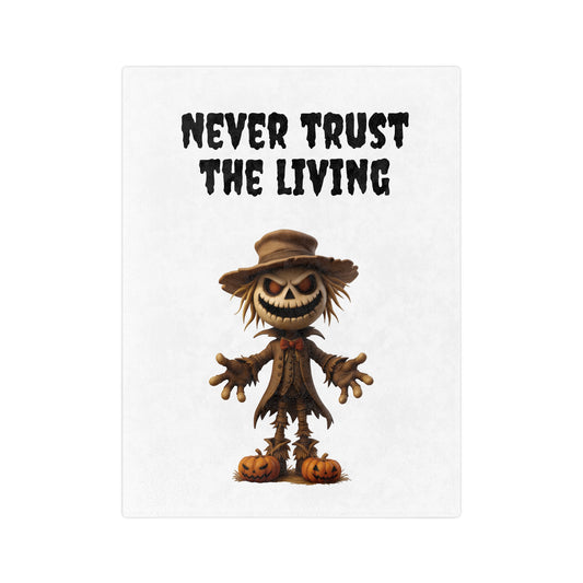 "Never Trust The Living" Spooky Scarecrow Halloween Plush Blanket with a grinning scarecrow standing on pumpkins and text on a white background.

