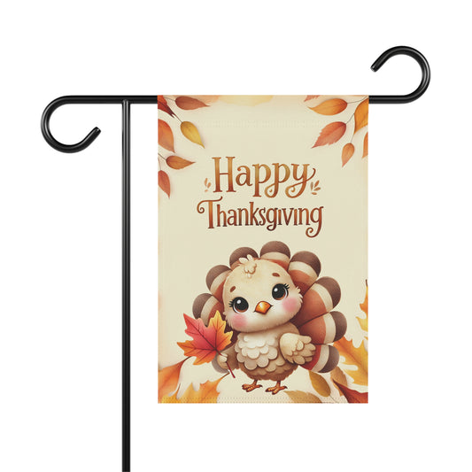 Thanksgiving garden flag featuring baby turkey holding a red leaf with autumn foliage background