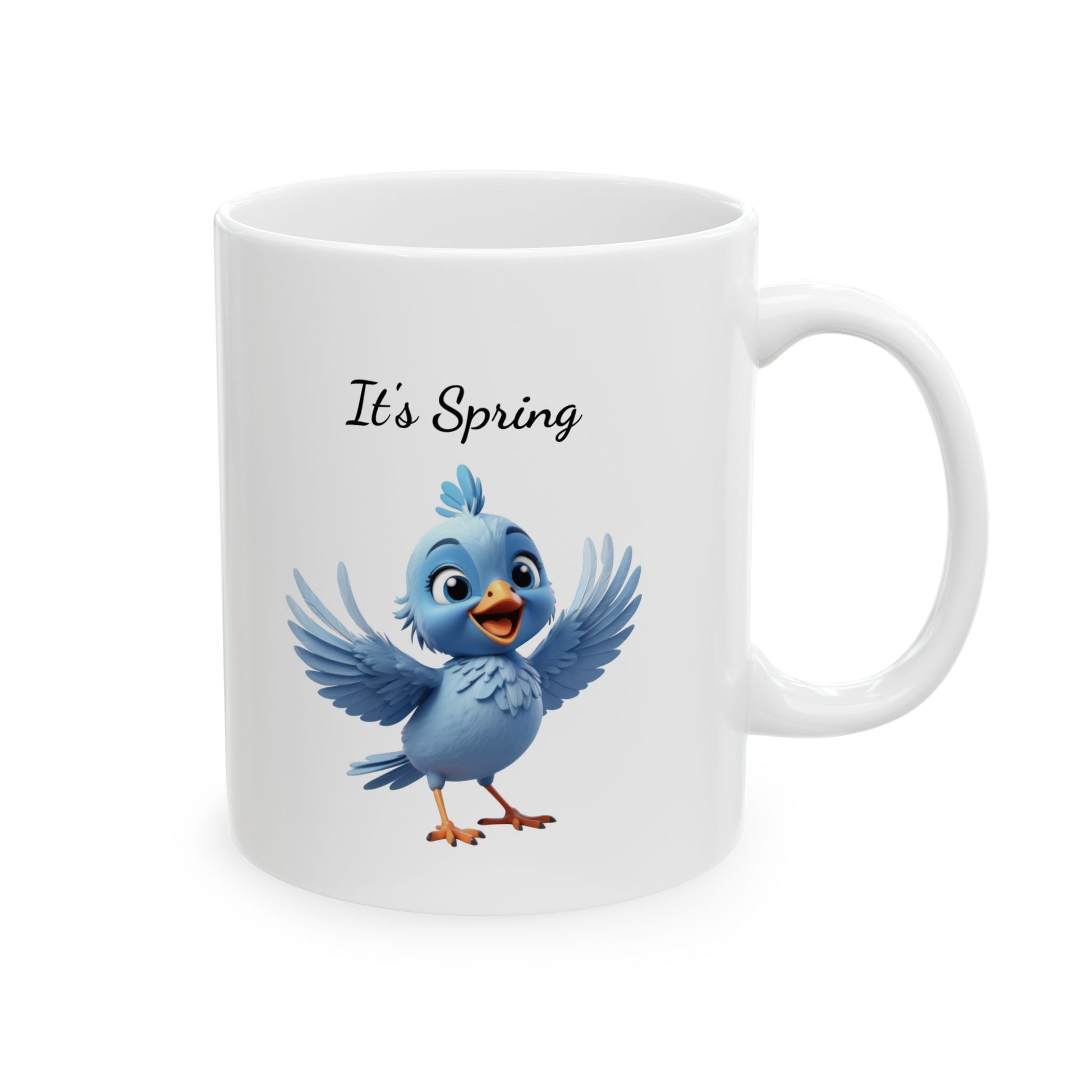 White ceramic coffee mug with a 3D-style illustration of a cute, cheerful blue cartoon bird with wide-open wings, and black text above reads "It's Spring!".