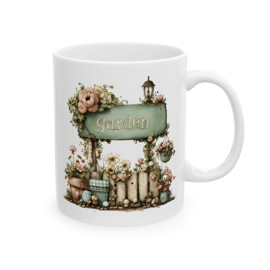 White ceramic coffee mug printed with a rustic green garden sign mounted on a flower-draped fence
