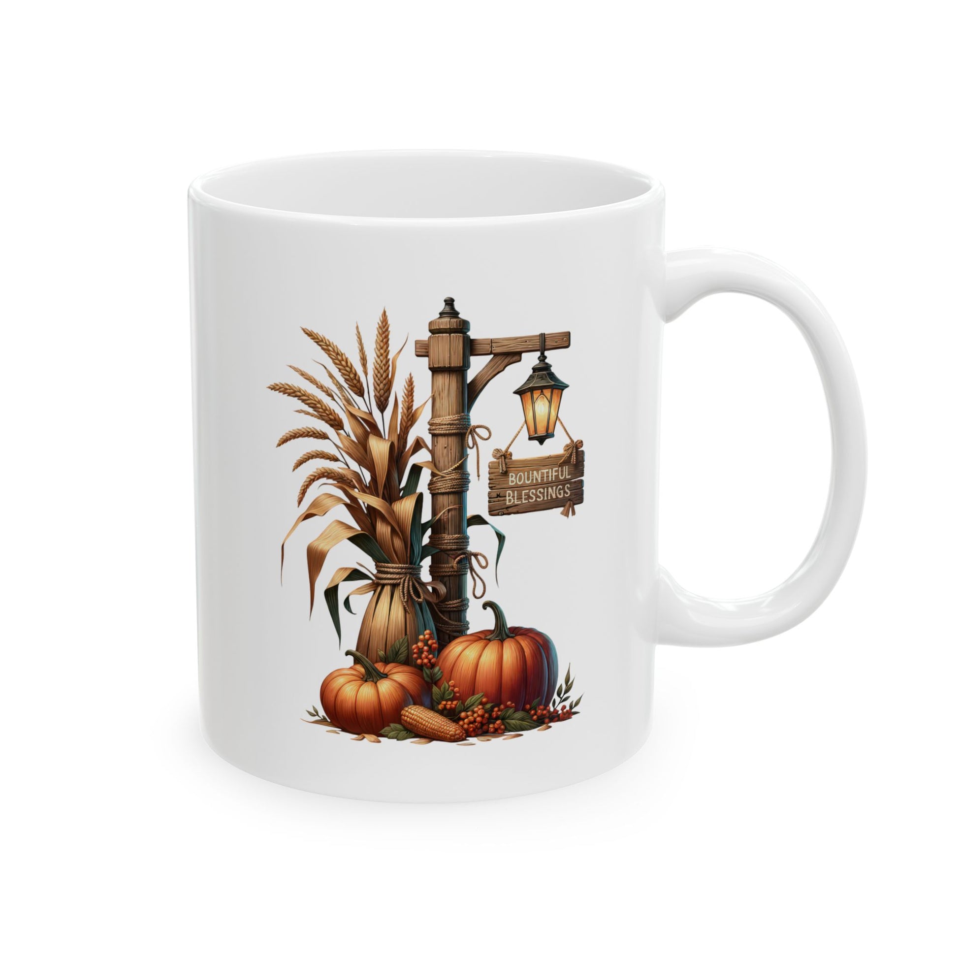 White ceramic coffee mug featuring a rustic farmhouse illustration of pumpkins, dried wheat stalks, an ear of corn, and a glowing lantern next to a wooden sign that reads Bountiful Blessings.
