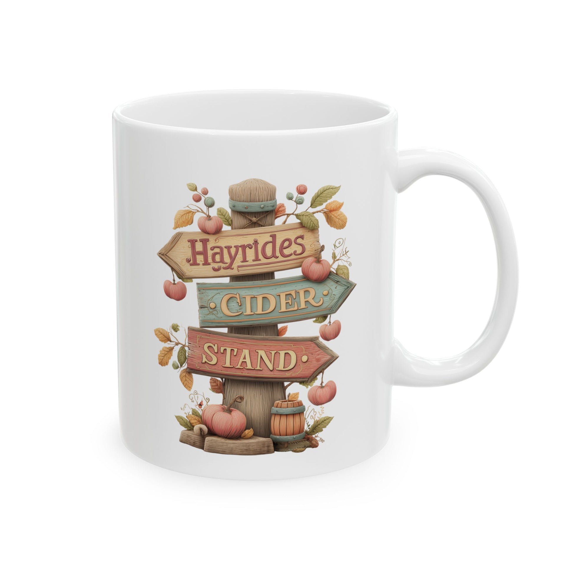 White ceramic coffee mug featuring an illustration of a rustic wooden signpost reading Hayrides CIDER STAND, surrounded by climbing vines, a small barrel, and a pumpkin.
