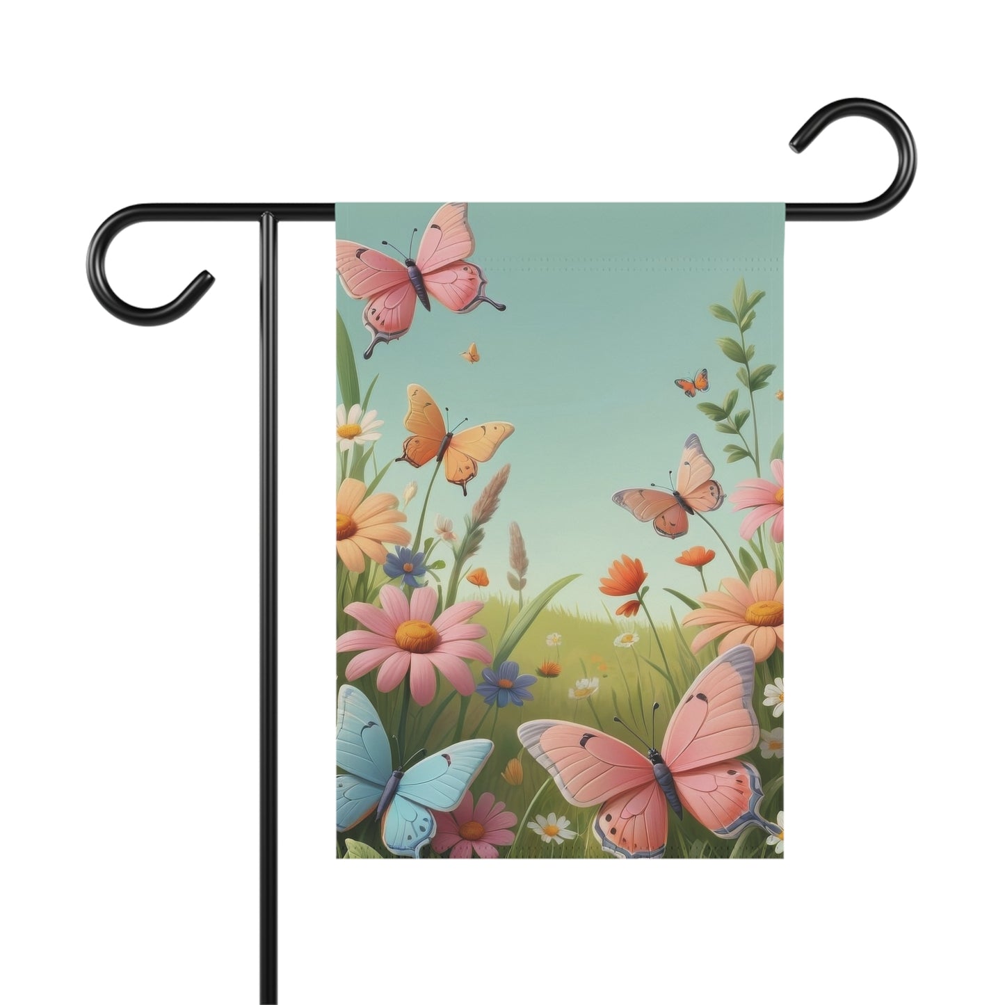 Garden flag displayed on a black metal pole, featuring a vibrant spring meadow scene with pink, orange, and blue butterflies flying amidst colorful daisies, wildflowers, and green grass under a light blue sky.


