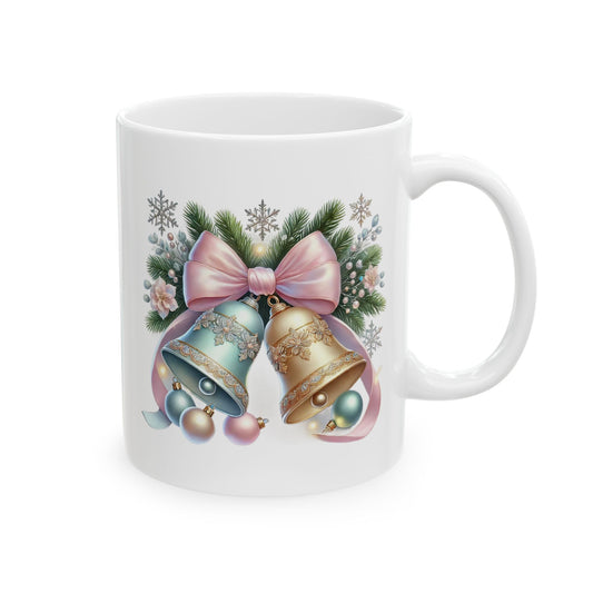 White ceramic coffee mug printed with an illustration of ornate gold and pastel blue Christmas bells topped with a large pastel pink bow and evergreen sprigs