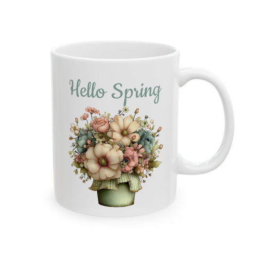 White ceramic coffee mug printed with sage green Hello Spring text above a lush arrangement of pastel flowers in a green potted planter