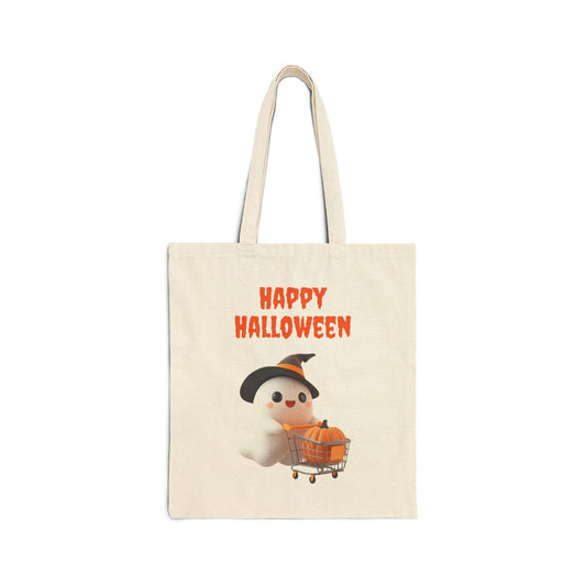 A cream-colored 100% cotton canvas tote bag featuring an illustration of a cute white ghost wearing a witch's hat and pushing a tiny shopping cart with a pumpkin inside. The text "HAPPY HALLOWEEN" is printed above the ghost.