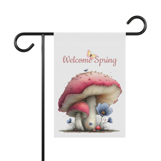 Outdoor garden flag featuring a whimsical red mushroom illustration with a butterfly beneath pink script text reading Welcome Spring.