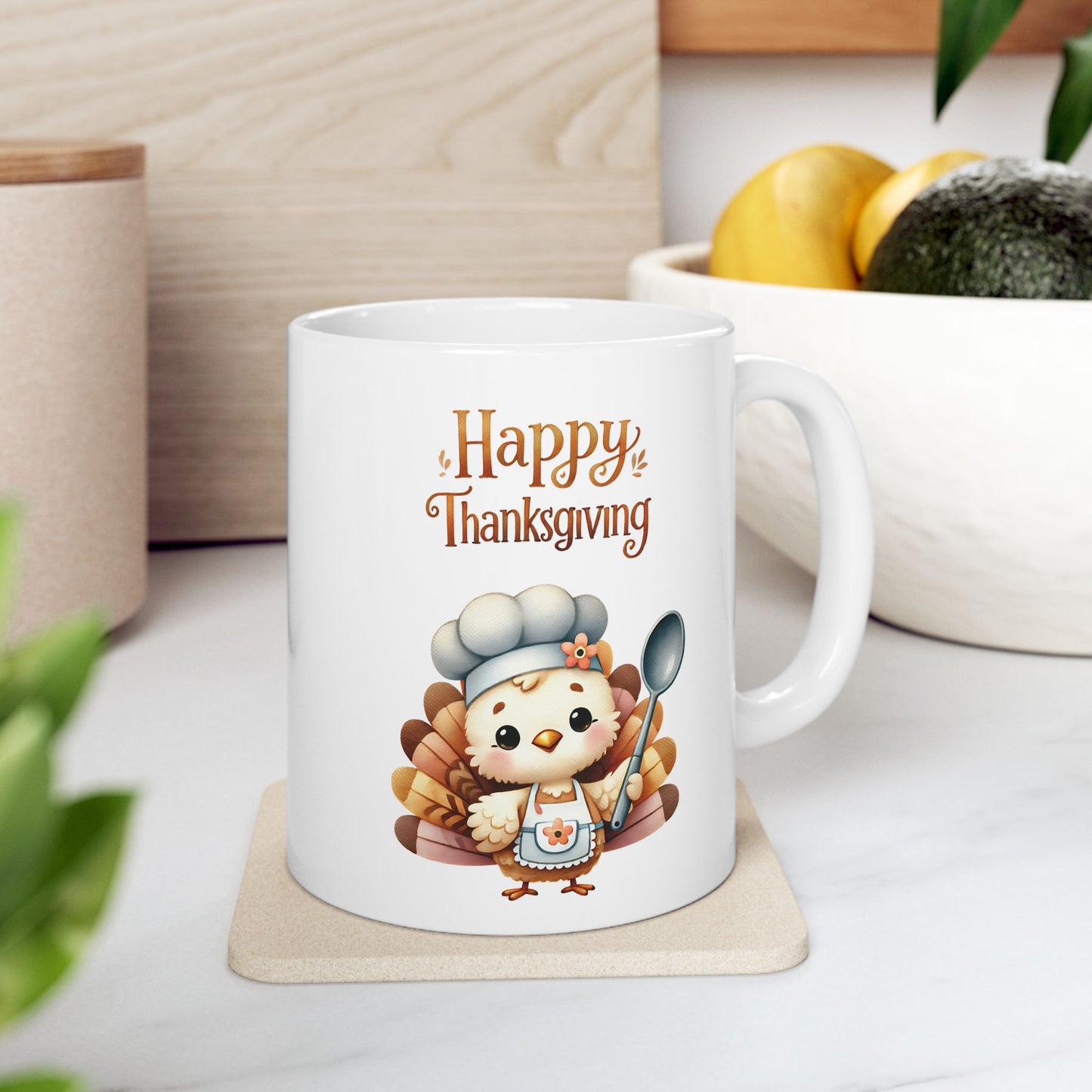 "White ceramic coffee mug with 'Happy Thanksgiving' text and a cute cartoon turkey wearing a chef's hat and apron, holding a spoon."