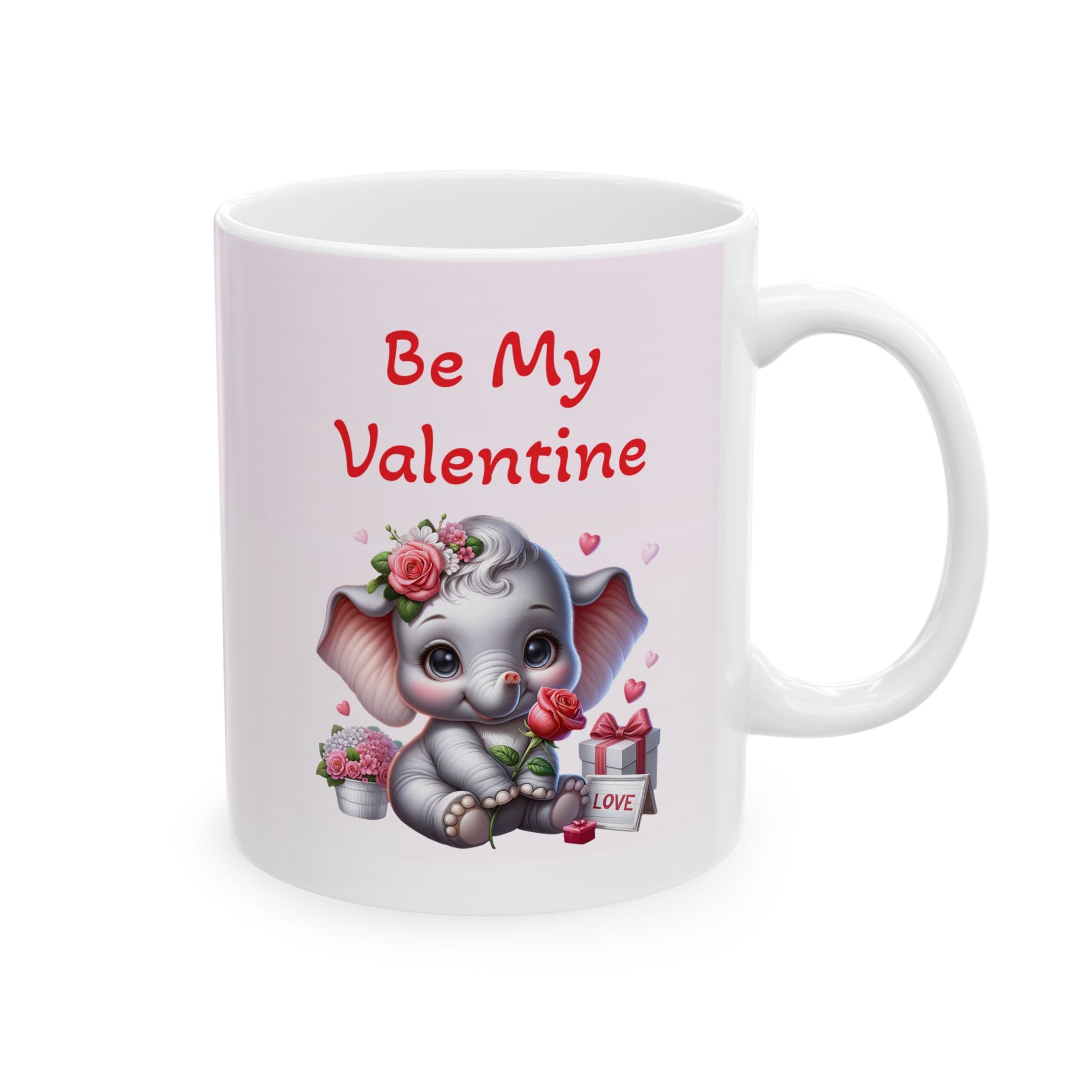 White ceramic coffee mug with 'Be My Valentine' text and a cute cartoon baby elephant surrounded by pink and red roses, hearts, and wrapped gifts, on a wooden background