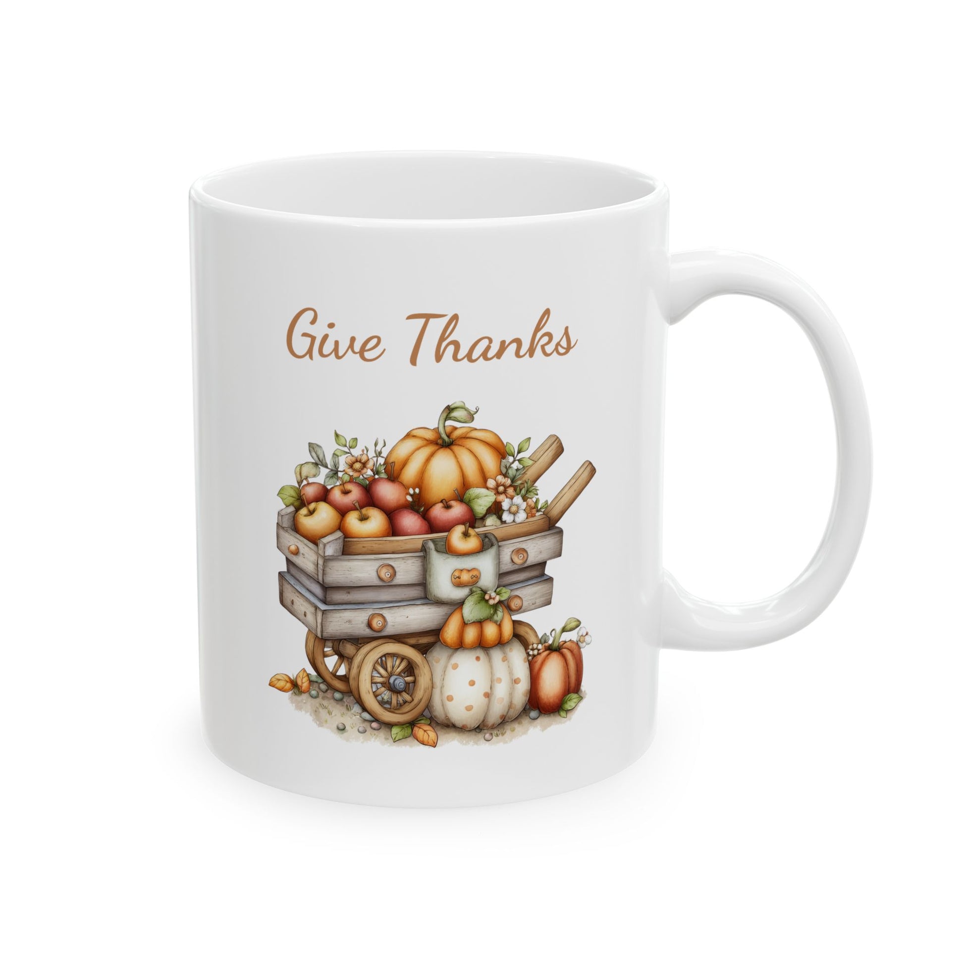 Give Thanks ceramic coffee mug featuring a cute illustration of a rustic wooden wagon filled with apples and a large pumpkin, with additional pumpkins underneath on the ground, under warm brown text.